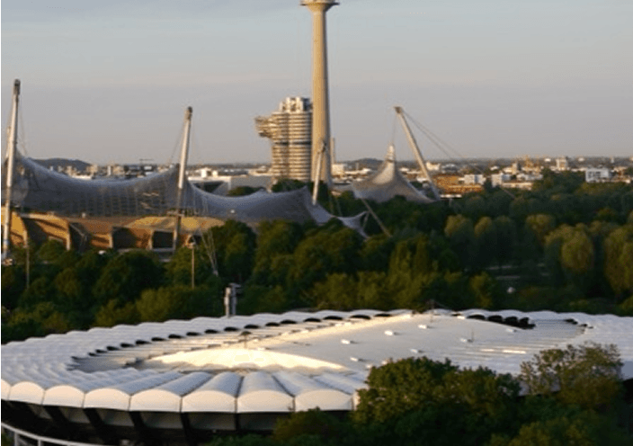 Olympiapark München mit Fanfest-Bühne vor Olympiaturm und Stadiondach.