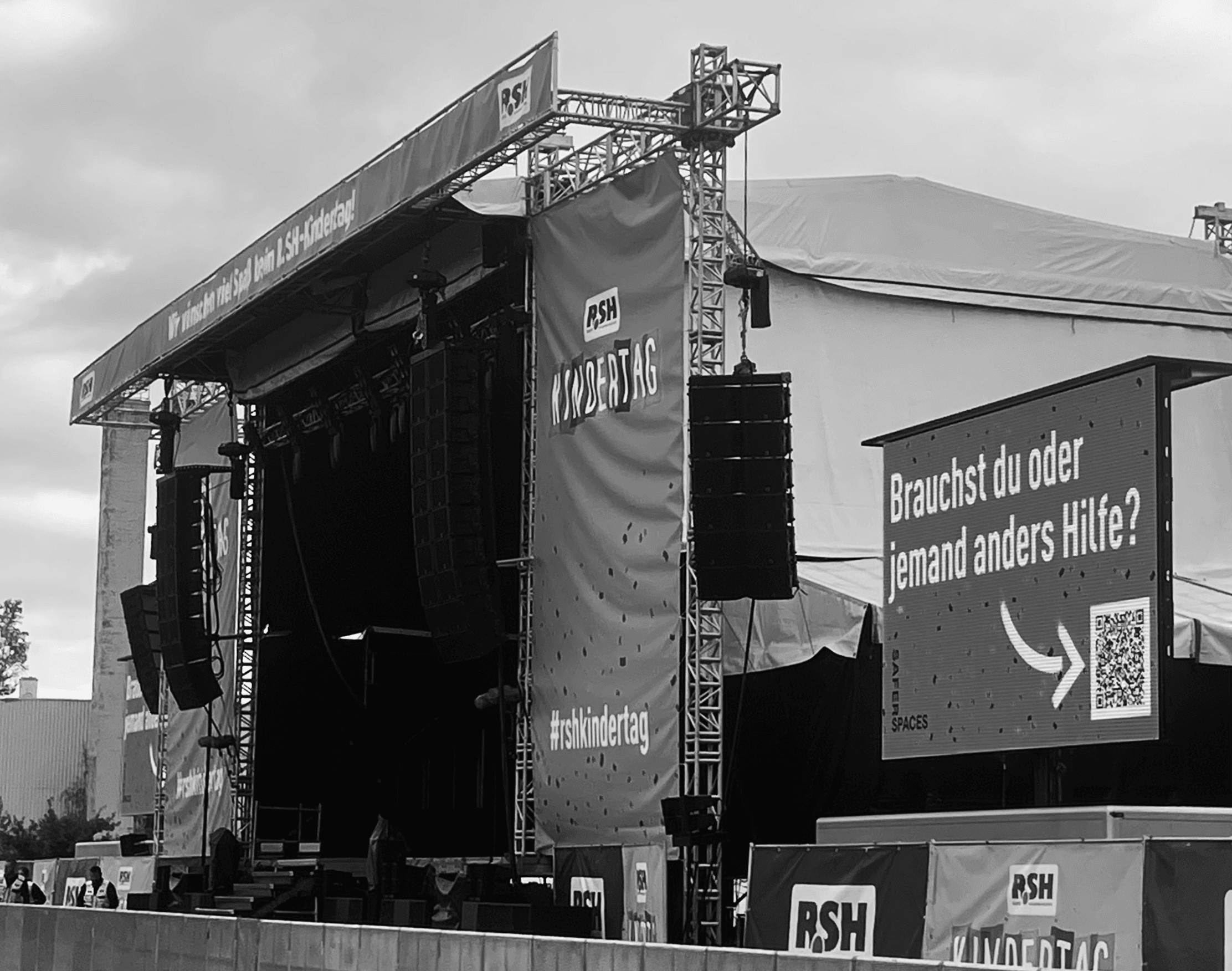 Stage with „RSH Kindertag“ banner and large screen: „Do you or does someone else need help?“ plus QR code.